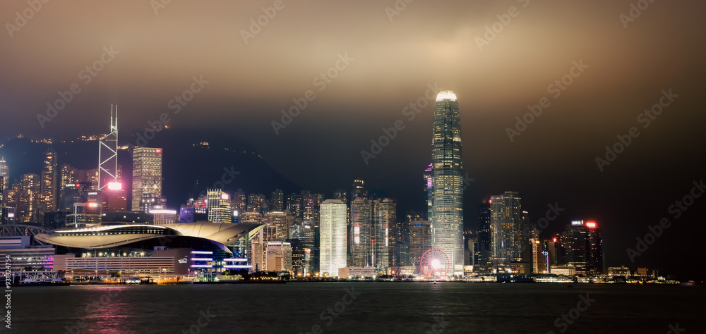 Fototapeta premium Night panorama showcasing the vibrant skyline of Hong Kong with illuminated skyscrapers and a serene harbor view