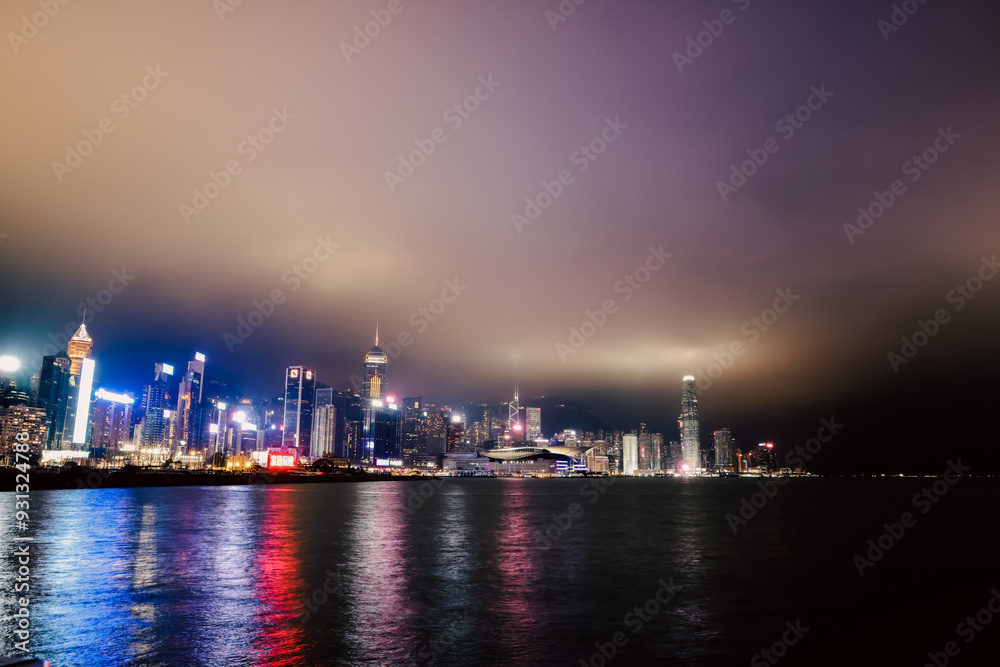 A night panorama of bright Hong Kong showcasing vibrant city lights and reflective waters A night panorama of bright Hong Kong showcasing vibrant city lights and reflective waters