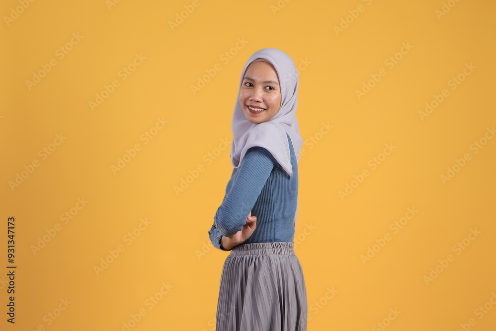 portrait of happy asian indonesian muslim woman with arm crossed on isolated yellow background portrait of happy asian indonesian muslim woman with arm crossed on isolated yellow background