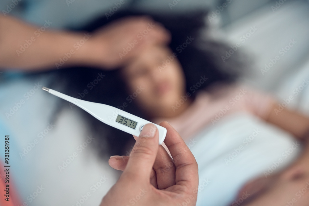Parents, child and thermometer for symptoms of fever, cold or virus in bedroom with worry, concern or care. Father, daughter and sick in home with temperature, check and wellness for medical advice Parents, child and thermometer for symptoms of fever, cold or virus in bedroom with worry, concern or care. Father, daughter and sick in home with temperature, check and wellness for medical advice