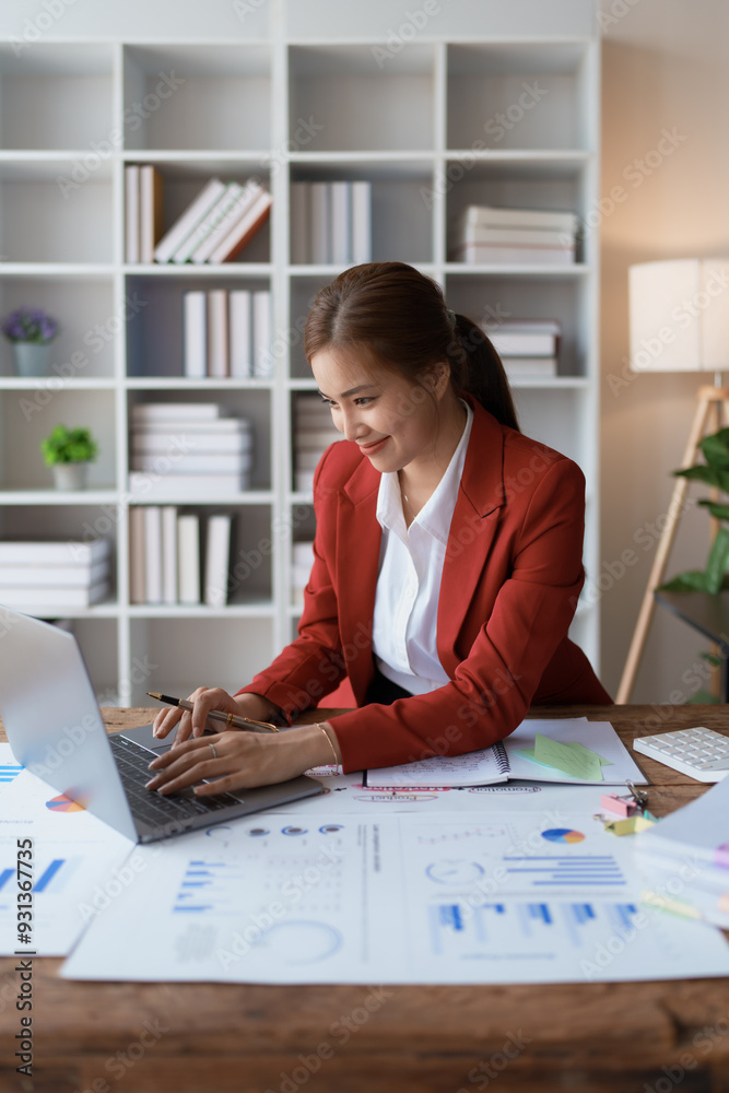 woman meticulously plans a finance audit, using a computer and calculator to review budget documents and ensure accuracy