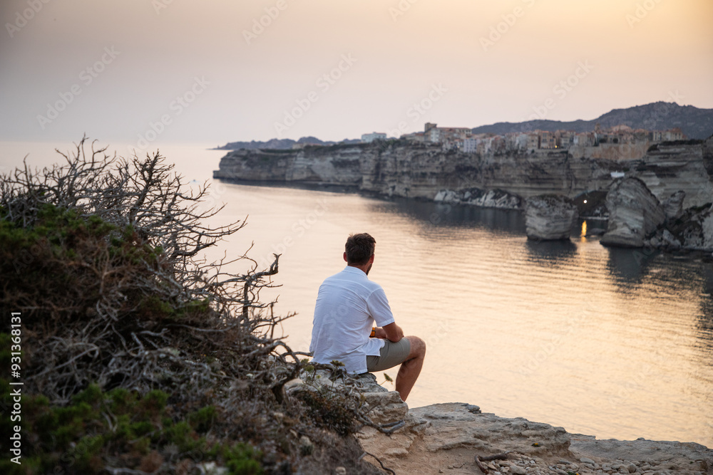 man watching the sunset over the Town of Bonifacio Corsica Island France man watching the sunset over the Town of Bonifacio Corsica Island France