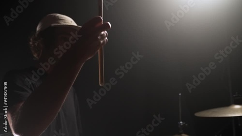 Slow motion close up of a male drummer twirling his one drumstick and striking his cymbals showing the vibrations of the cymbals photo