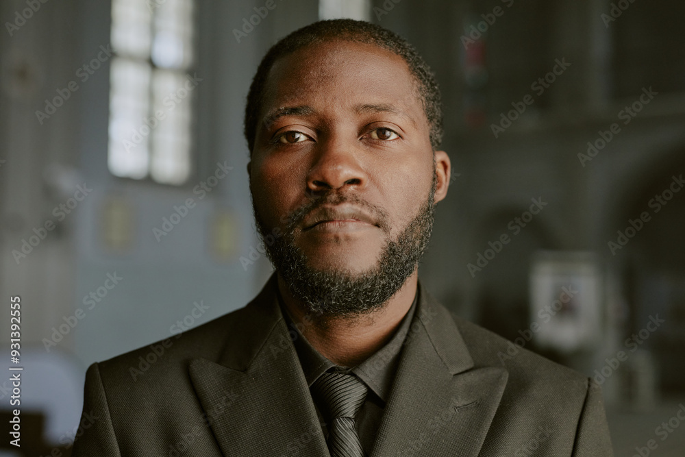 Naklejka premium Portrait of African American man dressed in black costume, he looking at camera with sorrow in eyes