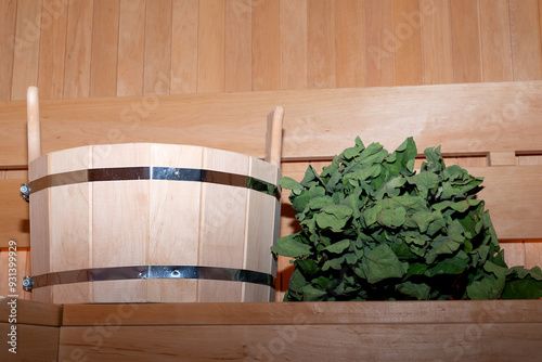 Steam bath room with traditional sauna bucket for soaking a broom and oak broom. photo