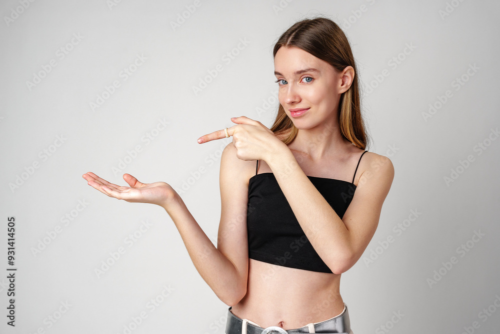 Young Woman Pointing to copy space in studio Young Woman Pointing to copy space in studio