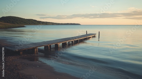 Wallpaper Mural A peaceful beach with a small wooden pier extending into the water. The calm, reflective surface of the ocean and the soft light of sunset create a serene and contemplative scene Torontodigital.ca