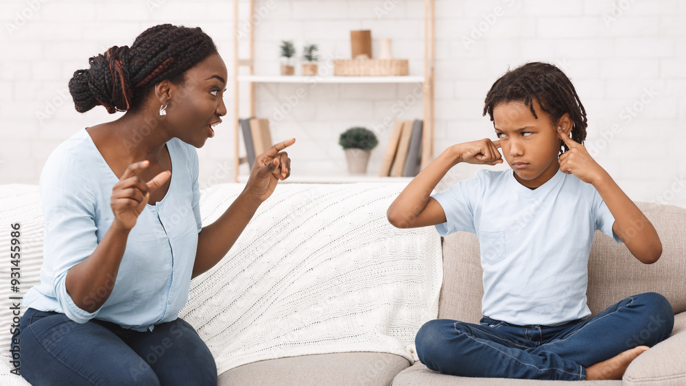 African Mother Scolding Her Daughter For Disobeying, Kid Putting Fingers In Ears With Grumpy Face African Mother Scolding Her Daughter For Disobeying, Kid Putting Fingers In Ears With Grumpy Face