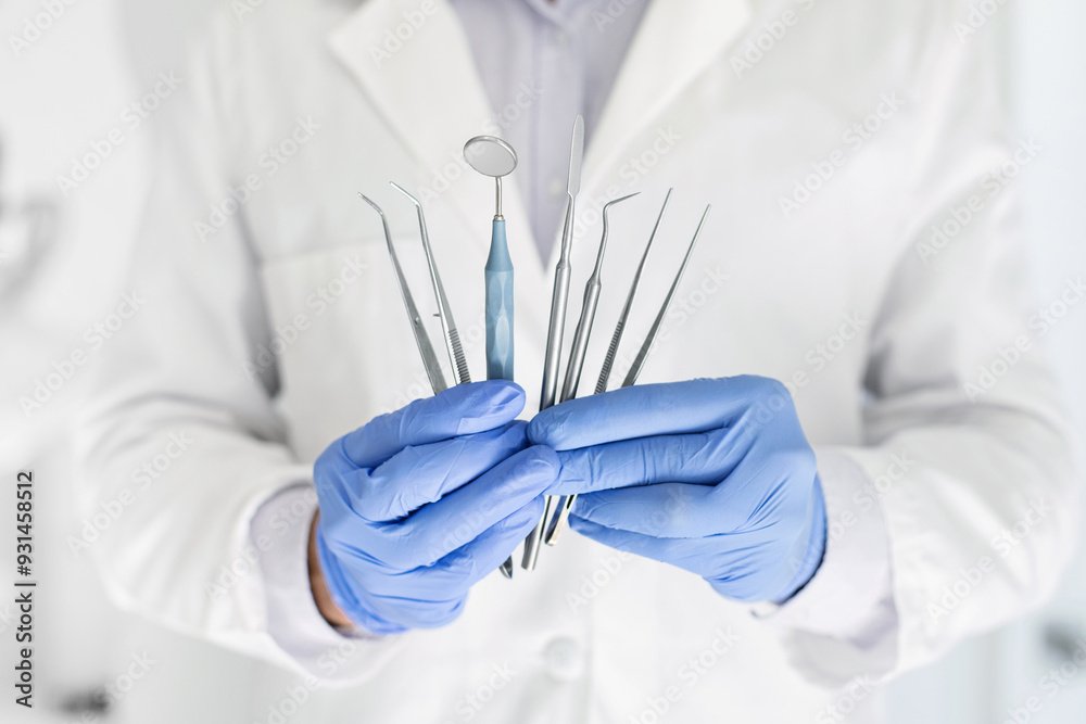 Doctor with blue gloves holding set of metal medical equipment tools for dental care, cropped Doctor with blue gloves holding set of metal medical equipment tools for dental care, cropped