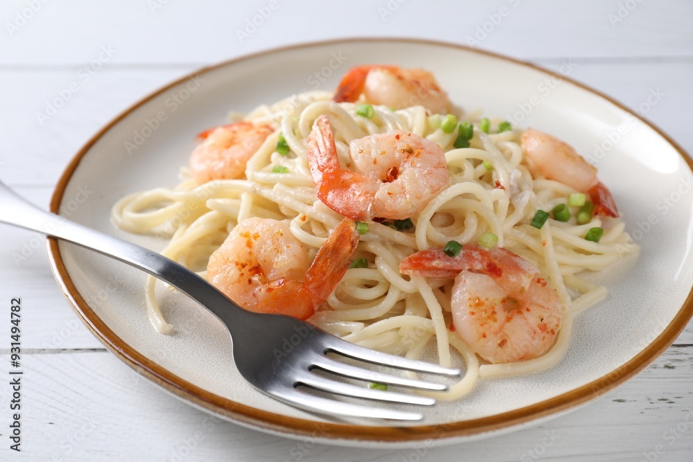 Delicious pasta with shrimps, green onion and fork on white wooden table, closeup Delicious pasta with shrimps, green onion and fork on white wooden table, closeup