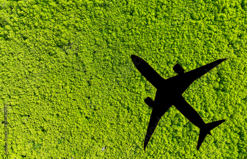 Shadow airplane flying above green mangrove forest. Sustainable fuel. Use biofuel in aviation for sustainable transportation. Reduction carbon emissions. Eco-friendly flight. Aviation sustainability. photo