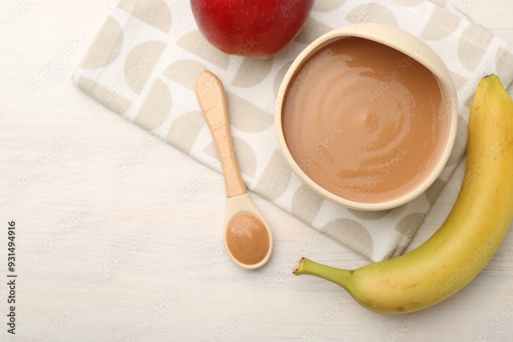 Delicious baby food in bowl and ingredients on white wooden table, flat lay Delicious baby food in bowl and ingredients on white wooden table, flat lay