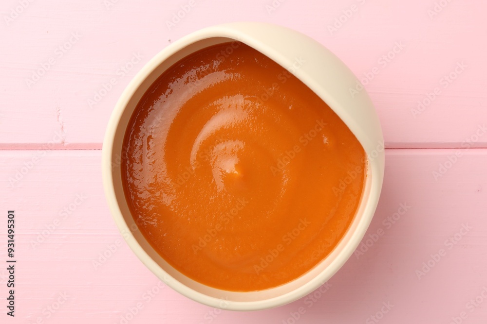 Delicious baby food in bowl on pink wooden table, top view Delicious baby food in bowl on pink wooden table, top view
