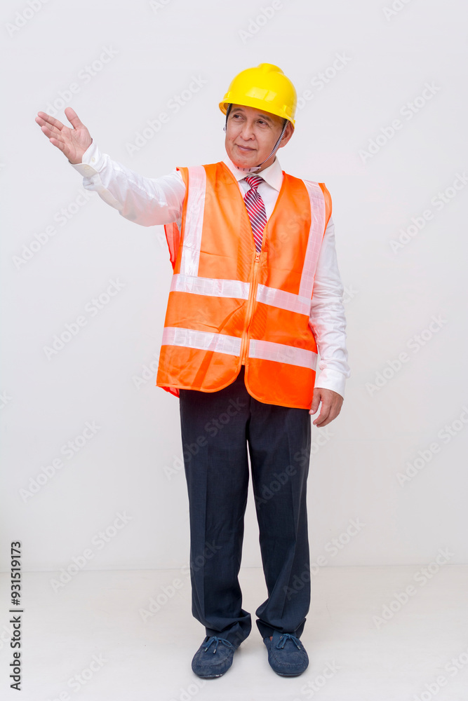 A middle aged asian construction project manager, or engineer wearing a safety hat and vest presenting something to the left with his hand. For editing purposes. Isolated on a white background. A middle aged asian construction project manager, or engineer wearing a safety hat and vest presenting something to the left with his hand. For editing purposes. Isolated on a white background.