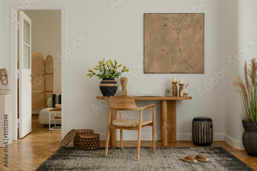 Modern living room interior with a minimalist design. Features a wooden table adorned with decorative vases and sculptures, a wooden chair with a woven seat, and a large abstract painting on the wall photo