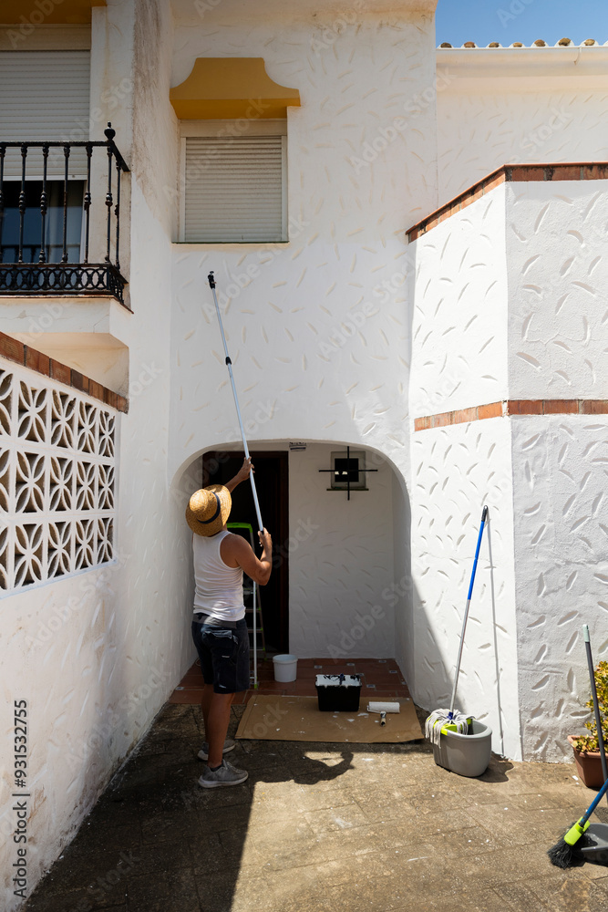 Obraz premium Caucasian man painting a house, perfect for home renovation and DIY projects