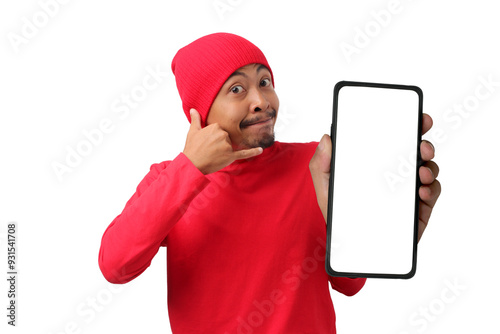 Young Indonesian man in a red long sleeve shirt shows a phone with an empty white screen while making a 