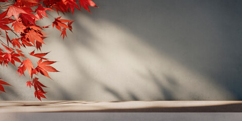 Autumn background scene with red maple leaves on table with sunlight. Natural seasonal home decor for fall season, thanksgiving and holiday showroom.