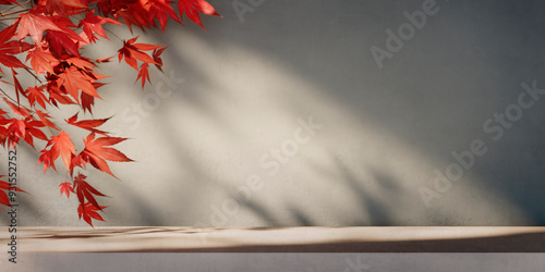 Autumn background scene with red maple leaves on table with sunlight. Natural seasonal home decor for fall season, thanksgiving and holiday showroom.