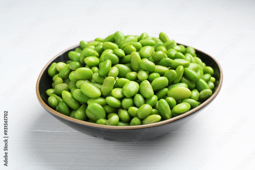 Fresh edamame soybeans in bowl on white wooden table, closeup Fresh edamame soybeans in bowl on white wooden table, closeup
