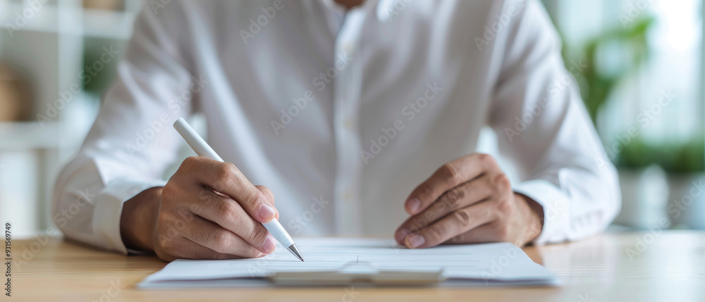Focused professional writing, a person in a white shirt intently writes on a blank notebook, surrounded by a bright workspace filled with greenery and soft light. Focused professional writing, a person in a white shirt intently writes on a blank notebook, surrounded by a bright workspace filled with greenery and soft light.