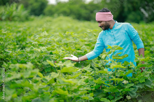 happy young Indian farmer standing in farm