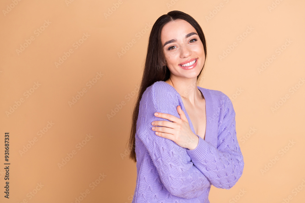 Portrait of nice young woman touch shoulder empty space wear cardigan isolated on beige color background Portrait of nice young woman touch shoulder empty space wear cardigan isolated on beige color background