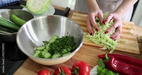 Wallpaper Mural Woman prepares fresh salad with cucumbers, cabbage and herbs in kitchen Torontodigital.ca