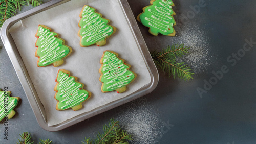 Frosted Green Christmas Tree Sugar Cookies on a Baking Sheet