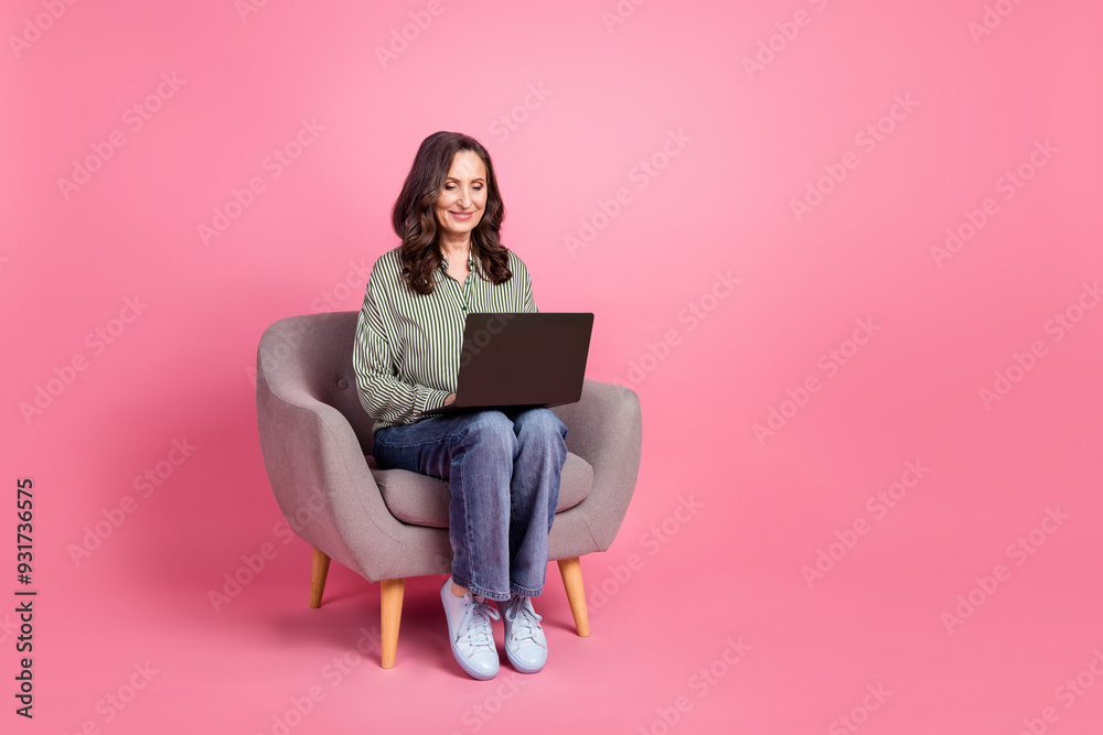 Full length photo of shiny attractive lady dressed striped blouse working modern device empty space isolated pink color background Full length photo of shiny attractive lady dressed striped blouse working modern device empty space isolated pink color background