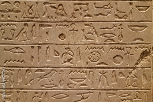 Ancient Egyptian stone carving with hieroglyphs, featuring intricate symbols and sacred inscriptions. photo