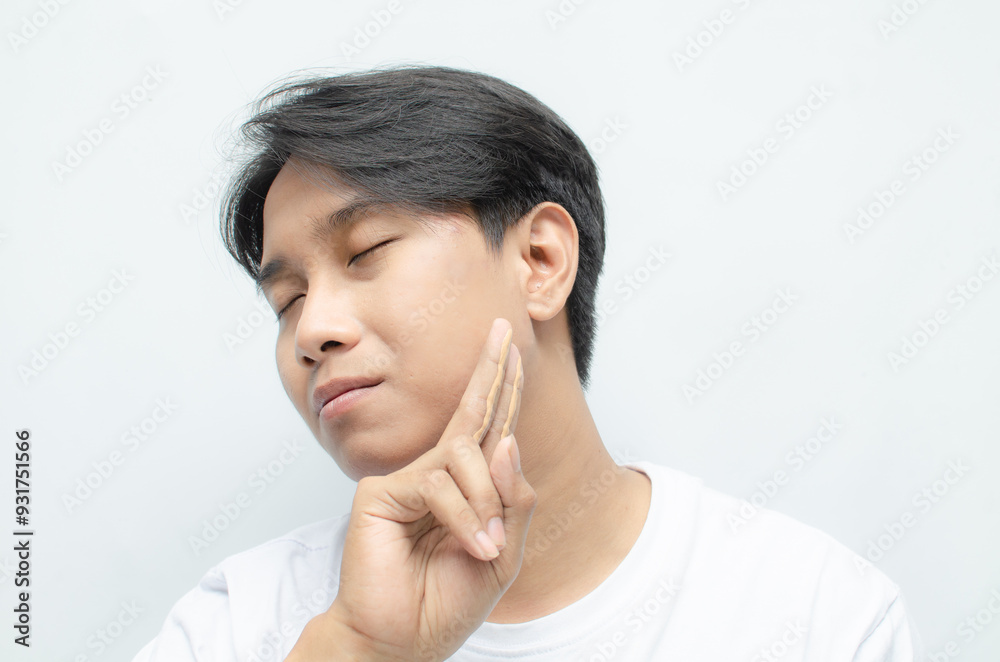 Close-up of a young asian man in white tshirt applying skincare cream to his face. skincare concept of asian man bare face. Close-up of a young asian man in white tshirt applying skincare cream to his face. skincare concept of asian man bare face.