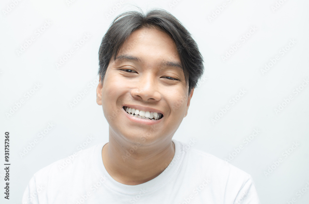 young asian man smiling and showing his crooked teeth isolated over white background. dracula teeth and bucktooth concept. overlapping teeth of man young asian man smiling and showing his crooked teeth isolated over white background. dracula teeth and bucktooth concept. overlapping teeth of man