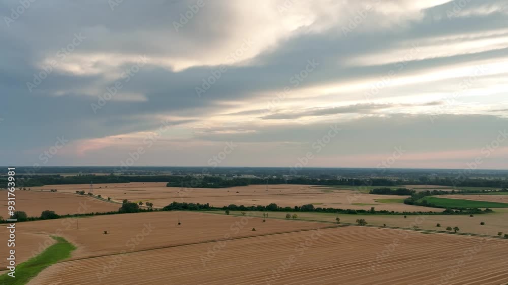 Aerial view of beautiful golden hour sunset over harvested fields. Flying above agricltural wheat land Aerial view of beautiful golden hour sunset over harvested fields. Flying above agricltural wheat land