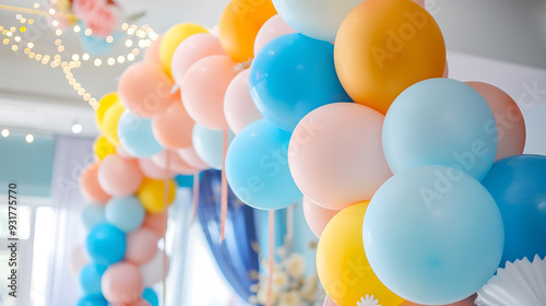 close-up shot of a decorative balloon arch at a party event. The arch is composed of balloons in soft pastel colors. colorful, blurred fairy lights, bright lighting.