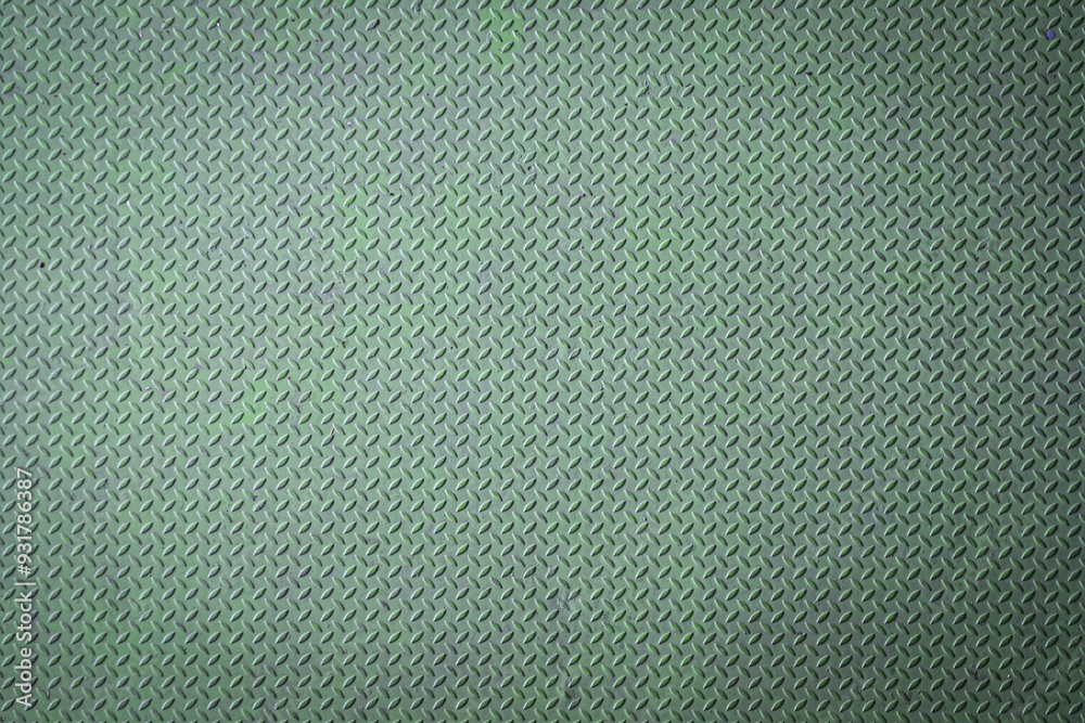 Close-up of green diamond plate metal texture with worn surface.