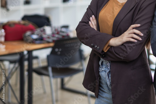 Asian businesswoman standing alone in office on blurred background with Copy Space for text. Asian businesswoman standing in office with high self confidence pose to show leadership.