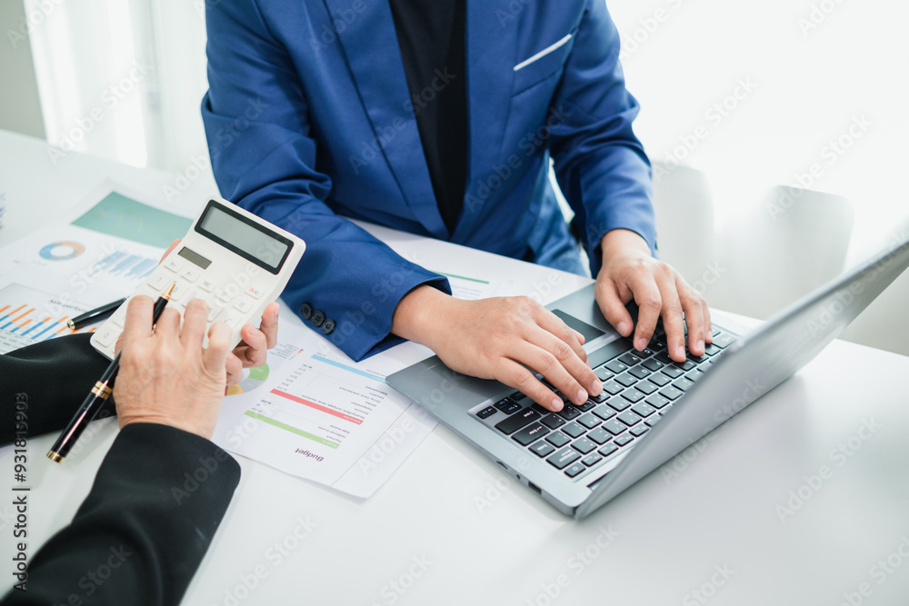 A businessman working on a laptop at his desk in an office environment A businessman working on a laptop at his desk in an office environment