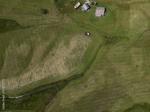 Harvesting grass in summer in Armentarola Aerial view of the Dolomites mountain landscape in Trentino, South Tyrol in Northern Italy. photo