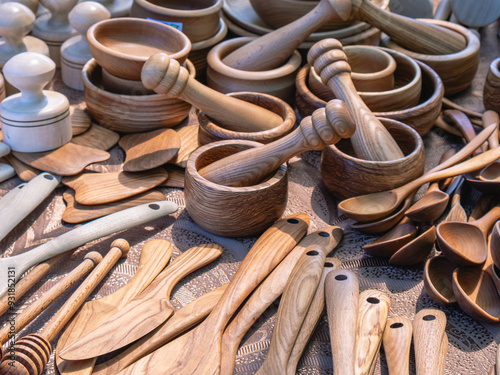 Wooden cutlery. Wooden kitchen utensils are displayed in the background. Wooden mortars and spoons. Folk crafts in rural areas.