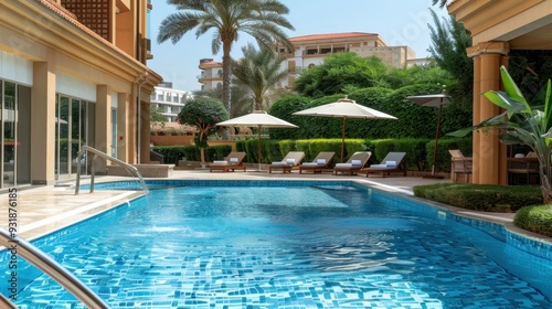 Relaxation by the refreshing outdoor pool, surrounded by luxurious loungers and lush greenery on a sunny day