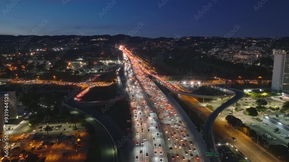 Marvel at the aerial 4K view of a severe traffic jam in downtown Los Angeles at night. The congested freeway glows with city lights, highlighting profound urban transportation challenges Marvel at the aerial 4K view of a severe traffic jam in downtown Los Angeles at night. The congested freeway glows with city lights, highlighting profound urban transportation challenges