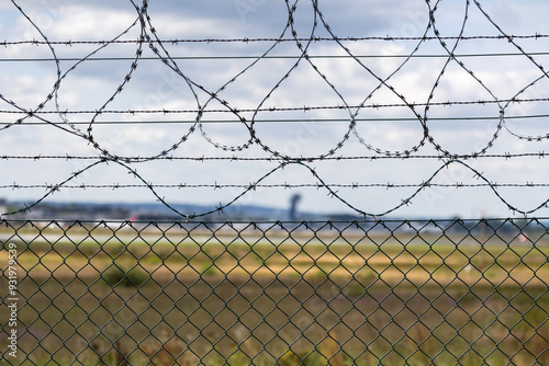 Detailaufnahme eines Sicherheitszauns mit Stacheldraht um das Gelände des  Airport Nürnberg. 