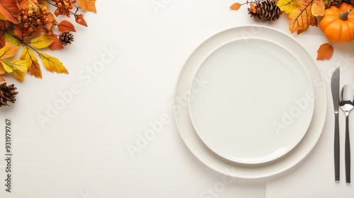 thanksgiving table setting with white plates and  autumn leaves, small pumpkins, and nuts on a light background. seasonal dining decor, holiday invitations, festive promotions. ample copy space