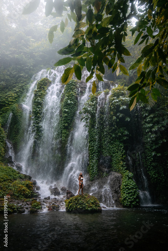 Young Woman Enjoying the Majestic Beauty of Banyu Wana Amertha Waterfalls, Bali photo