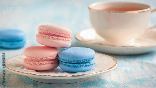 Pink and Blue Macarons on a Plate with Teacup in Background