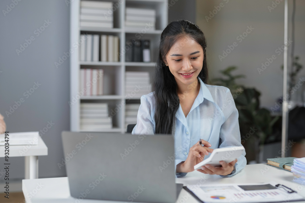 Accountant is smiling and calculating financial data for a business plan while working in an office Accountant is smiling and calculating financial data for a business plan while working in an office