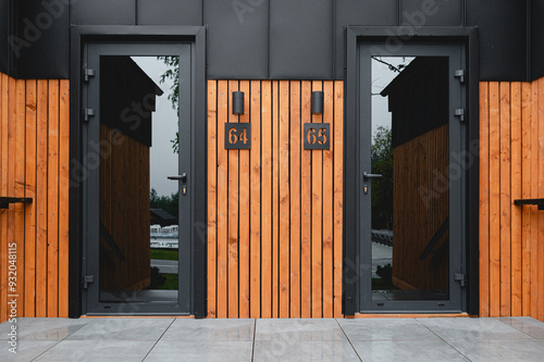 Entrance door of a wooden house. Metal construction with a glass insert. Modern.