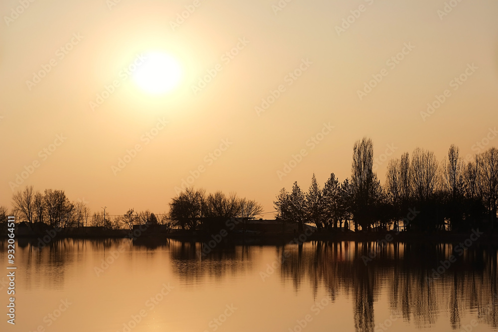 Fototapeta premium Beautiful autumn landscape of sunset. lake and silhouettes leafless trees in evening park. reflection in water. fall season atmosphere nature. harmony peaceful image. golden hour landscape