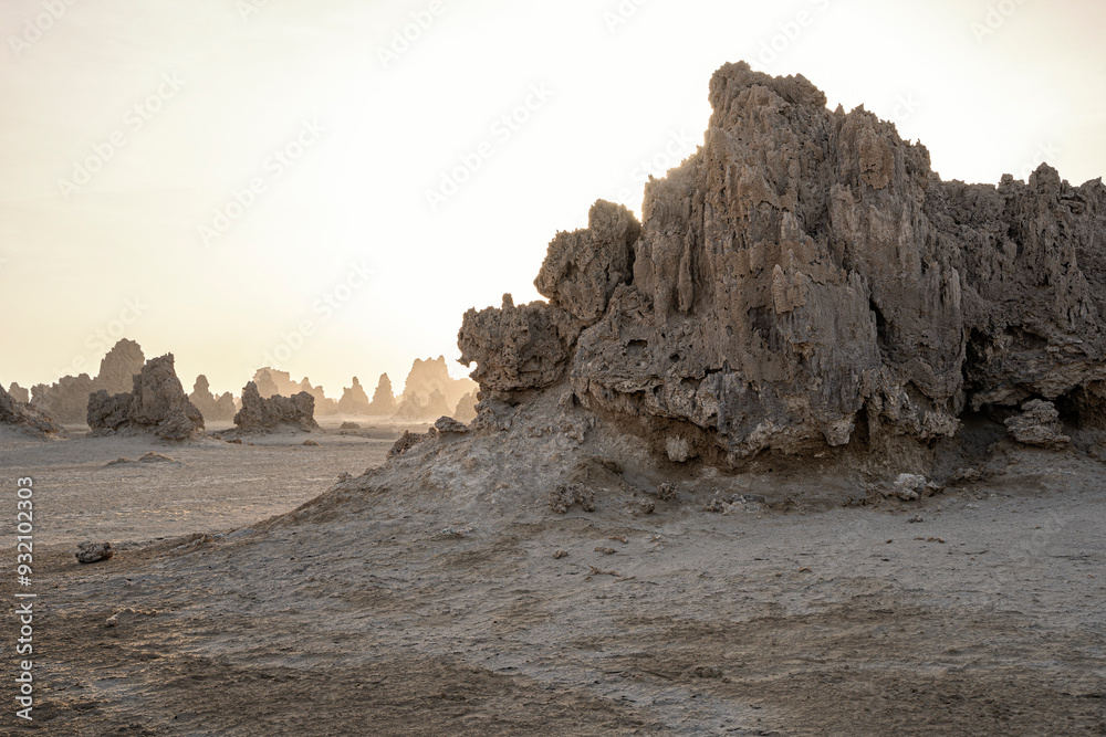 Moon landscape of limestone chimneys geological rock formations in a sunset rays at the bottom of dried salt lake Abbe, Djibouti